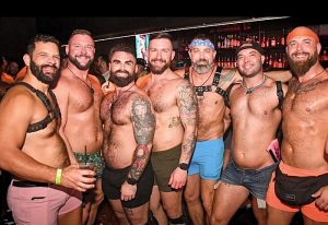 Gay Fort Lauderdale: Group of shirtless men at The Eagle Wilton Manors, a popular gay bar. Some wear harnesses and colorful shorts.
