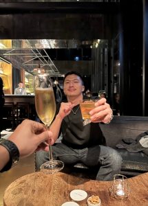 Gay Taipei Hotel Proverbs bar scene. Man cheers with drinks. Most booked gay hotels in Taipei City Center for gay men travelers.