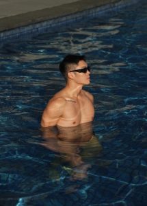 Gay travel: Man in pool at Le Meridien Melbourne, Australia. Muscular build, sunglasses. Leslie, enjoying a luxury hotel vacation.