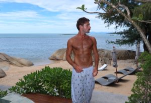 Gay beach hotspot, Rocky's Boutique Resort Samui. Man at Koh Samui's Veranda Collection, a gay-friendly resort with beach access, lounge chairs.