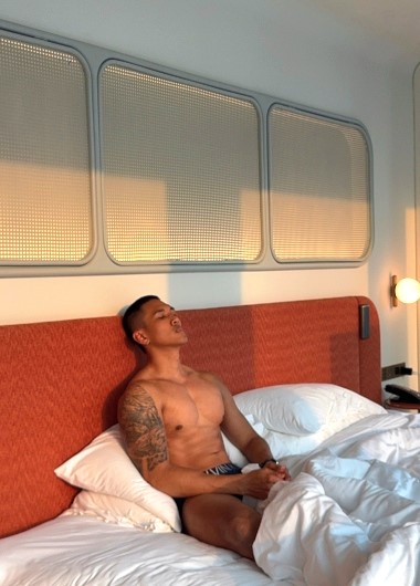Gay travel: Man relaxing in bed at The Standard, Bangkok Mahanakhon. Thailand hotel stay. Andee-14.jpg. Bangkok travel advice.