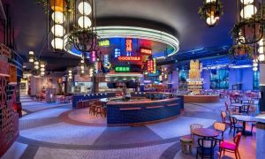 Interior of Gay-Friendly Las Vegas Hilton at Resorts World. Neon signs, bars, tables, and seating create a vibrant, welcoming atmosphere.