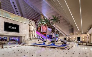 Luxor Hotel interior. Gay-friendly hotel with Egyptian theme, statues, palm trees, and pyramid architecture. Las Vegas travel advice.