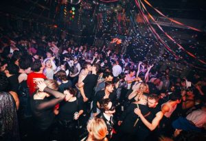 Gay nightlife in New York. A crowded dance floor at 3 Dollar Bill in New York, confetti falling, with gay men dancing and kissing.