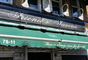 Friend's Tavern in New York. A gay-friendly bar with a welcoming vibe. There is always time for friends is written on the green awning.