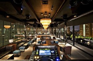 Dream Downtown Hotel's gay-friendly bar. Luxurious interior with a chandelier, DJ booth, and city views. A top gay travel destination.