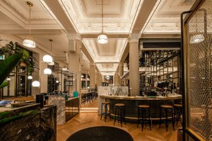 Hotel Birks Montreal's gay-friendly bar area. Elegant interior with marble counters, stylish lighting, and herringbone wood floors.