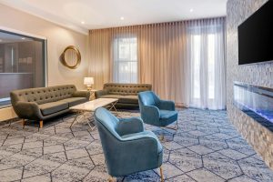 Quality Inn Centre-Ville's stylish lounge area. Sofas, blue chairs, and modern decor create a welcoming space in this gay-friendly hotel.