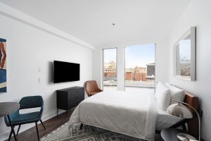 Sonder Gare Saint Denis gay-friendly hotel room. Clean design with a bed, TV, dresser, table and chairs. Modern, bright, and comfortable.