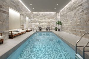 Indoor pool at The Hazelton Hotel, a gay-friendly hotel. The pool has a unique tile design. Chairs and lounges are nearby. Relaxing spa.