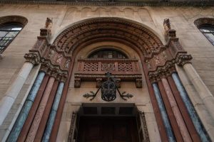 Ornate entrance to West Side YMCA Hostel, a gay-friendly hotel. Architectural details include carved stone, columns, and an arched doorway.