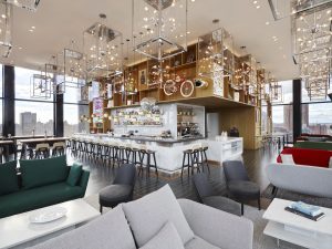 citizenM New York Bowery's stylish bar area. This gay-friendly hotel features modern decor, city views, and a vibrant atmosphere.