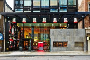 citizenM New York Times Square entrance. Gay-friendly hotel with modern design, red accents, and glass facade. A great choice for gay travelers.