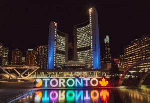 Toronto City Hall at night. Brightly lit Toronto sign with a maple leaf. Gay Toronto Travel Guide.