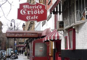 Marie's Crisis Cafe, a gay sing-a-long bar in New York City. Features a red awning and signage for live jazz and blues. Gay travel destination.