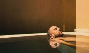 Gay man relaxing in a pool at a New York bathhouse. Popular gay bathhouses listed for gay men, travel advice.