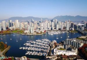 Gay Vancouver travel guide: Aerial view of Vancouver's skyline, marina with yachts, and mountains. Number one destination for gay men travelers.