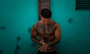 Tattooed man under shower. Sauna and bathhouse image for Vancouver gay cruise clubs, gay travel. Gay sauna, bathhouse experience.