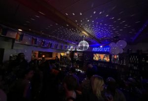 Inside The Lodge at O'Gradys gay bar in Toronto. Disco ball, rainbow flags, & Absolut sign. Gay travel advice for men.