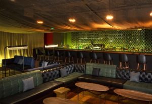 Mesh interior of a gay bar. Stylish seating, bar stools, and a well-stocked bar create an inviting atmosphere for gay men travel.