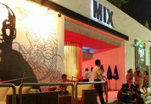 Mix Club entrance at night. Gay bar with dragon mural, red lighting, and people outside. Gay travel advice. 700X480-3.jpg