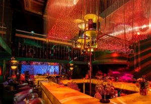 Interior of Asia Blue, a gay bar in Shanghai, China. The bar is lit with red and orange lights and has a modern design. Gay travel.