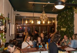 Interior of Beans Bar in Melbourne, a gay-friendly travel destination, with patrons at the bar and ambient lighting.
