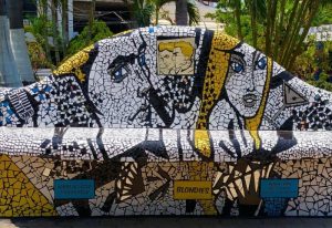 Mosaic bench art at Blondies Loft Slush Bar, a gay party spot in Puerto Vallarta. Features portraits & Blondies name. Gay travel.