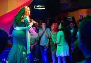 Drag queen performing at Cabaretito El Taller gay bar in Mexico. Crowded venue with excited audience enjoying the show. Gay nightlife.