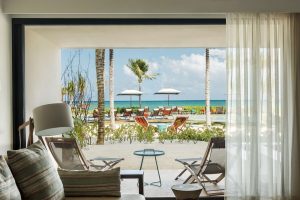 Andaz Mayakoba Resort Riviera Maya, a gay-friendly hotel by Hyatt. Ocean view from a room's patio with beach chairs and palm trees.
