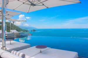 Hotel Mousai Cancun adults-only all-inclusive gay-friendly hotel. Infinity pool, ocean view, lounge chairs, and umbrellas. Perfect for gay travel.