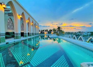 Layla Tulum Adults Only gay-friendly hotel rooftop pool at sunset. Arches, lanterns, and intricate tile work create a luxurious vibe.