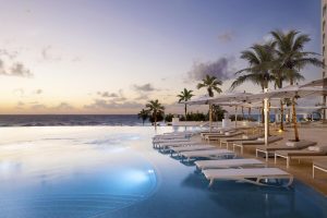 Le Blanc Resort Cancun adults-only all-inclusive gay-friendly hotel. Infinity pool, beach, palm trees, lounge chairs at sunset.