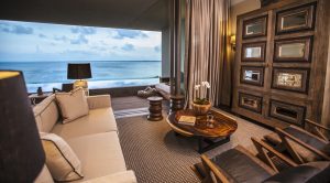 Nizuc Resort and Spa gay-friendly hotel room. Ocean view suite with sofa, wood furniture, and balcony. Luxury travel for gay men.