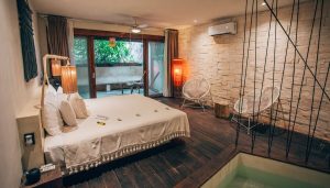 Orchid Beach House Adults Only gay-friendly hotel room. Bedroom with king bed, chairs, and private balcony. Gay travel lodging.
