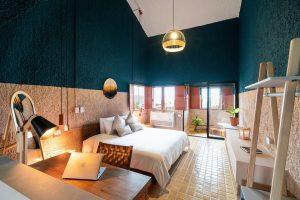 Selina Cancun Laguna Hotel Zone gay-friendly room. Modern design, laptop on desk, bed, and balcony. Ideal for LGBTQ+ travelers.