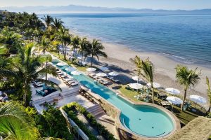 W Punta de Mita gay-friendly hotel: aerial view of pool, beach, and ocean. Palm trees and lounge chairs create a relaxing vibe for gay travelers.