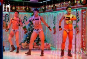 Hotmale Club Bangkok go-go boys. Three Asian dancers in zebra print briefs and boots on stage at a gay bar. Christmas decor in the background.