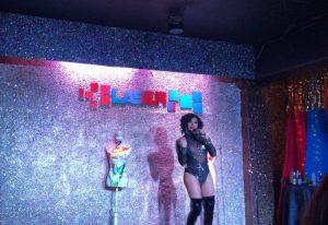 Drag queen performs at Laser Hot Bar, a popular gay bar in Cancun. Nightlife scene with stage, lights, and performer. Gay travel destination.