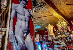 Reinas Bar, a gay place in Puerto Vallarta. Interior view with a David statue poster and a male torso mannequin hanging from the ceiling.