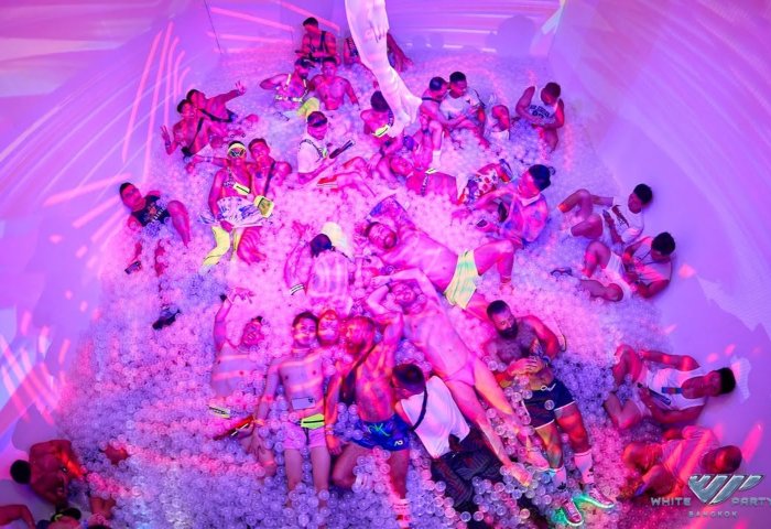 Gay men at White Party Bangkok, enjoying a ball pit. Travel advice for gay tourists. Nightlife, fun, and shirtless men in swimwear.