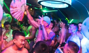 Ho Chi Minh gay bar scene. A lively crowd of shirtless men party at a gay bar in Ho Chi Minh City, Vietnam. Nightlife, travel advice.