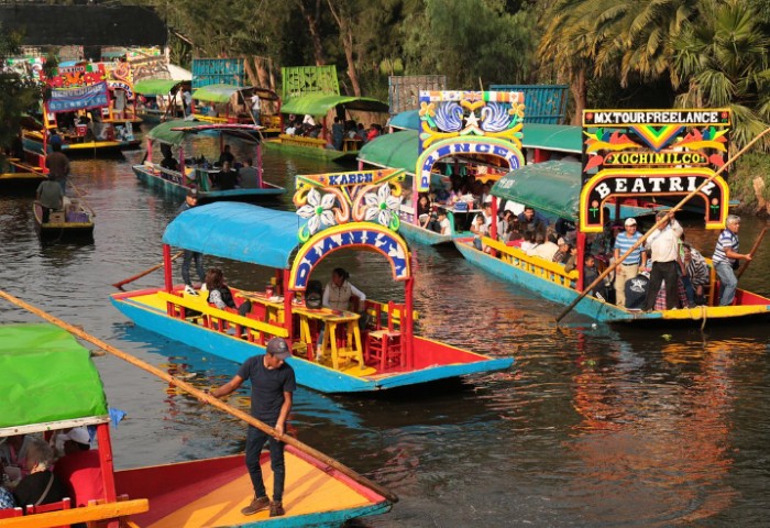 Xochimilco canals, Mexico City. Colorful trajineras boats with tourists. Popular LGBTQ travel destination near Coyoacan.