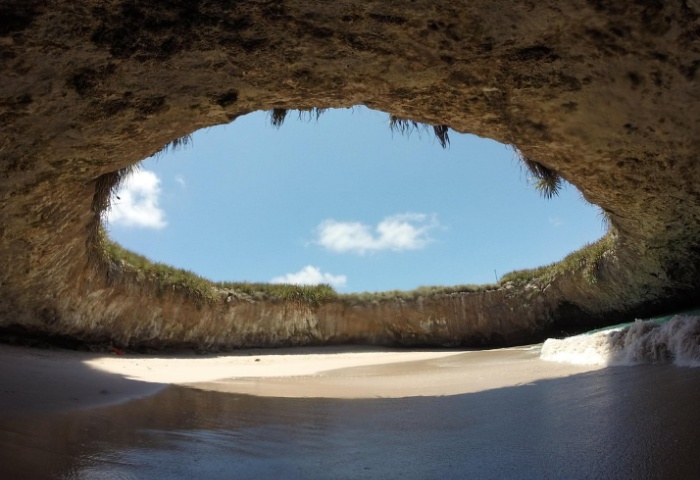 Puerto Vallarta's Playa del Amor (Hidden Beach): View from inside the cave, showing sand, water, & sky. Gay travel destination.