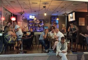 People at DD's s Bar, a gay bar in Benidorm, Spain, enjoying drinks. Interior view. Gay travel advice. Nightlife scene.