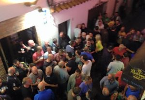 Busy El Horno Gay Bar in Sitges. A crowd of gay men are enjoying drinks and socializing at this popular gay travel destination.