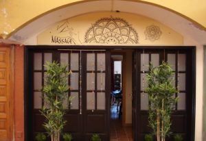 Entrance to Esku Massage in Maspalomas, Gran Canaria. A gay massage place featuring bamboo plants and a mandala design above the door.