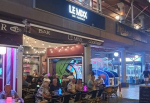 Le Mixx Gay Bar in Gran Canaria. Outdoor seating area with patrons. Nightlife scene at a popular gay bar. Bar and cocktails.