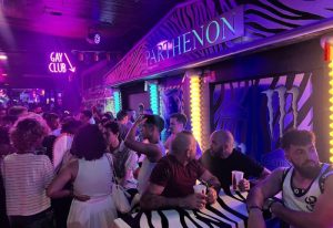 Inside the Parthenon Gay Cruise Club in Torremolinos. Zebra print bar, neon lights, and a crowd of gay men enjoying the night.