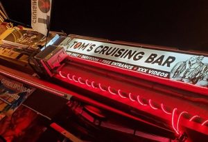 Tom's Cruising Bar, a gay club in Gran Canaria. Neon sign with men only and darkroom. Gay travel destination for men.